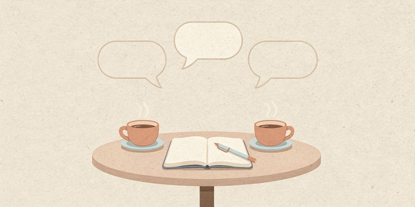 Two coffee cups and an open notepad on a small cafe table, with a few empty speech bubbles floating above